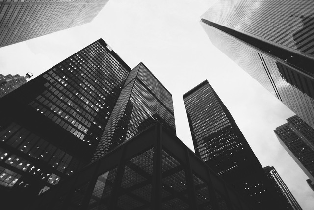 After: Looking up at glass skyscrapers in a city financial district, edited with the free Black & White LUTs