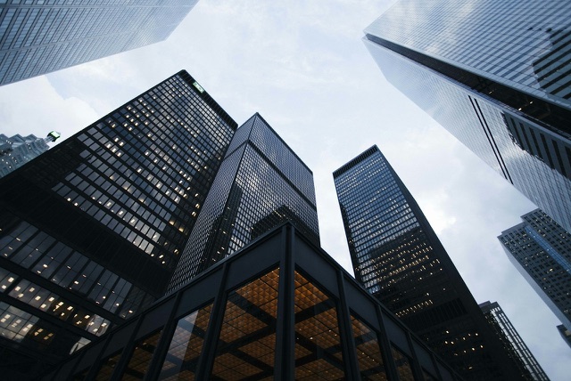 Before: Looking up at glass skyscrapers in a city financial district