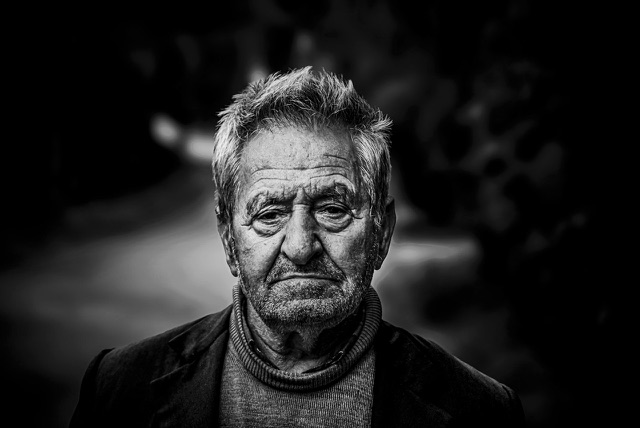 After: Close-up street portrait of an older man with gray hair, edited with the free Black & White LUTs