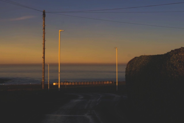After: Coastal road with streetlights and utility poles at dusk, edited with the free Cinematic LUTs