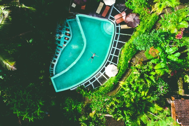 After: Aerial view of a turquoise swimming pool surrounded by tropical jungle, edited with the free Color Boost LUTs