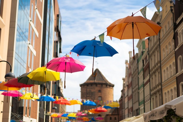 Before: Colorful umbrellas suspended above a city street