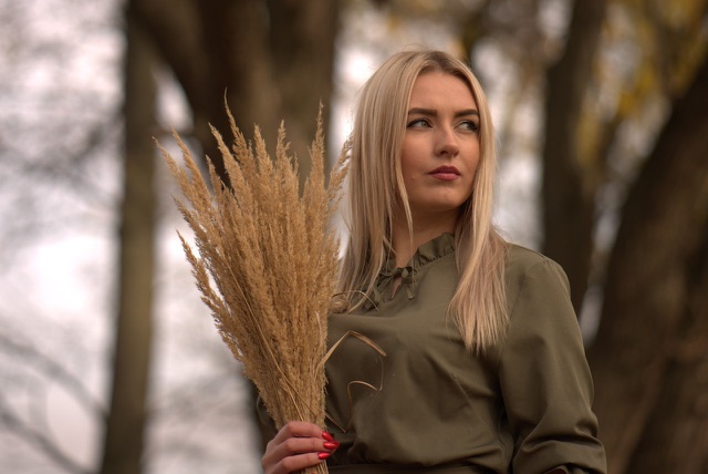 Before: Woman holding a bundle of dried pampas grass outdoors