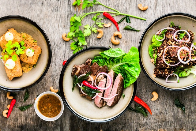 After: Overhead food photo of plated dishes on a rustic wooden table, edited with the free Lifestyle & Commercial LUTs